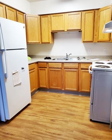 St. Charles apartment for rent - a kitchen with wooden cabinets and a refrigerator and a sink