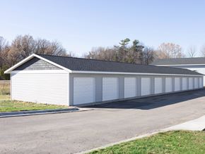 Mankato townhouse for rent - A long white garage with a black roof and a white car parked in front.