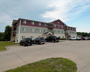 Jackson apartment for rent - Two black trucks parked in front of a red and white building.