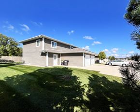 Eagle Lake townhouse for rent - A house with a grey roof and a green lawn in front.