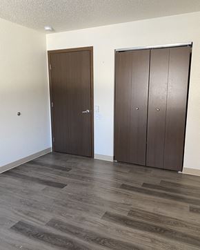Willmar apartment for rent - an empty living room with two doors and a wooden floor