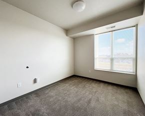 Forest Lake apartment for rent - A room with a window and a grey carpet.
