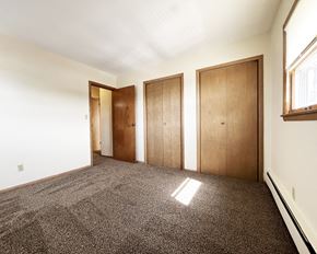 Mankato apartment for rent - an empty room with three doors and a carpeted floor