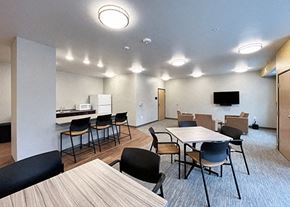 St. Louis Park apartment for rent - a community room with tables and chairs and a kitchen