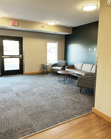 Forest Lake apartment for rent - a living room with couches and chairs and an exit door