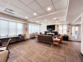 Rochester apartment for rent - A conference room with a carpeted floor and a television mounted on the wall.