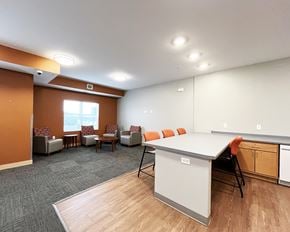 Mankato apartment for rent - A conference room with a white table and orange chairs.
