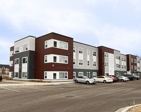 Mankato apartment for rent - A parking lot in front of a multi-story apartment building.