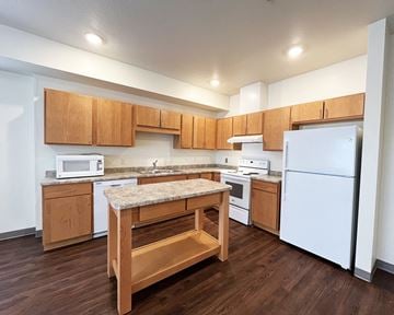Mankato apartment for rent - A kitchen with wooden cabinets and a white refrigerator.