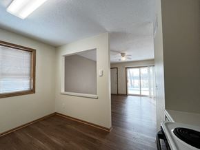 Mankato townhouse for rent - an empty kitchen and living room with wood flooring and a ceiling fan