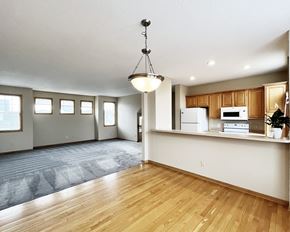 Faribault townhouse for rent - A kitchen with wooden floors and white appliances.