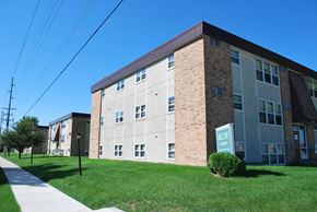 Mankato apartment for rent - a brick building with a green lawn in front of it