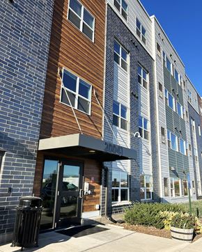 Forest Lake apartment for rent - a brick building with a glass door and a brown and gray facade
