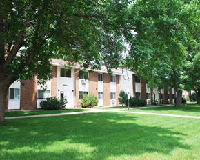 Westbrook apartment for rent - a large brick apartment building with green grass and trees