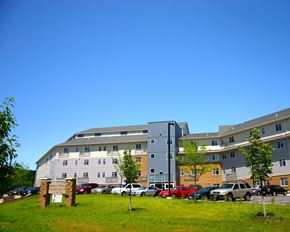 Mankato apartment for rent - A parking lot in front of a multi-story apartment building.