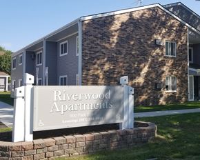Cannon Falls apartment for rent - a sign for riverwood apartments in front of a building