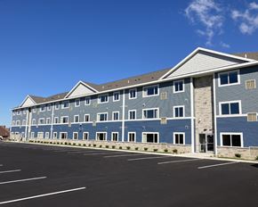 Owatonna apartment for rent - A large building with a parking lot in front.