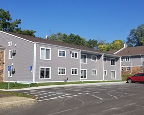 Cannon Falls apartment for rent - a building with a parking lot and a red car in front of it