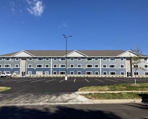 Owatonna apartment for rent - A large building with a parking lot in front of it.
