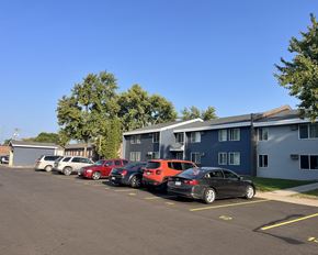 Cokato apartment for rent - a parking lot full of cars in front of a building