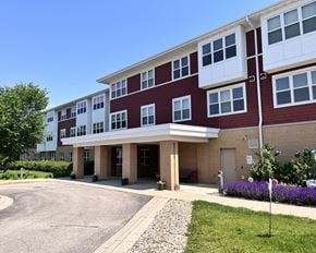 Rochester apartment for rent - A red and white building with a clear blue sky in the background.