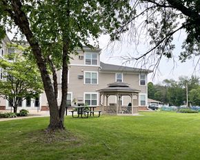 Northfield apartment for rent - A tree stands in front of a building with a gazebo in the front yard.