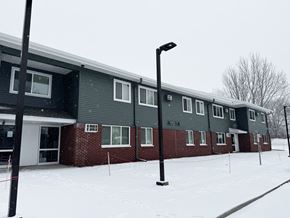 Alexandria apartment for rent - A building with a grey roof and red brick walls is surrounded by snow.