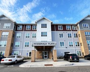 Forest Lake apartment for rent - Fitzgerald Flats is a multi-story residential building with cars parked in front.