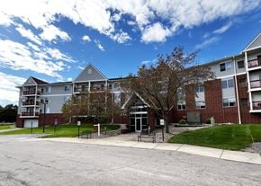 New Ulm apartment for rent - A large apartment complex with a parking lot in front.