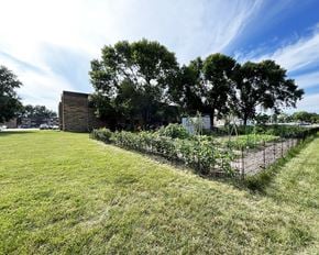 Mankato apartment for rent - A grassy field with a fence and a building in the background.