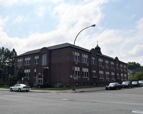 Hastings townhouse for rent - A large brick building with a street in front of it.