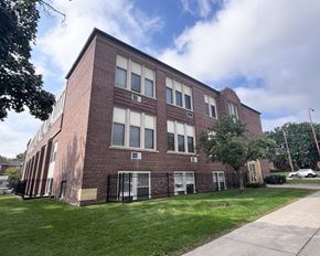 Hastings townhouse for rent - A red brick building with a black fence in front.