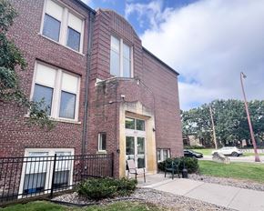 Hastings townhouse for rent - A red brick building with a black iron fence in front.