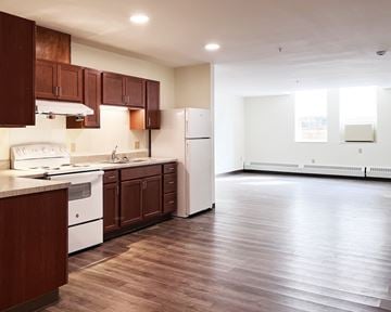 Hastings townhouse for rent - A kitchen with brown cabinets and white appliances.