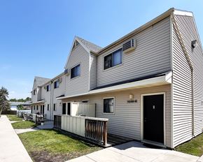 Rochester apartment for rent - A modern house with a black door and a balcony.