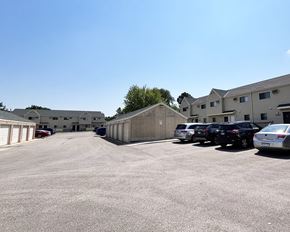 Rochester apartment for rent - A parking lot with cars and buildings in the background.