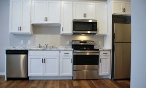 Mankato townhouse for rent - a kitchen with white cabinets and stainless steel appliances