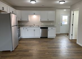 Belle Plaine townhouse for rent - a kitchen with white cabinets and stainless steel appliances