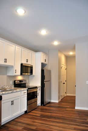 Mankato townhouse for rent - a kitchen with white cabinets and stainless steel appliances