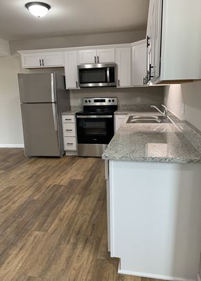 Belle Plaine townhouse for rent - a kitchen with white cabinets and stainless steel appliances