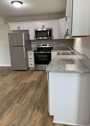 Eagle Lake townhouse for rent - a kitchen with white cabinets and stainless steel appliances