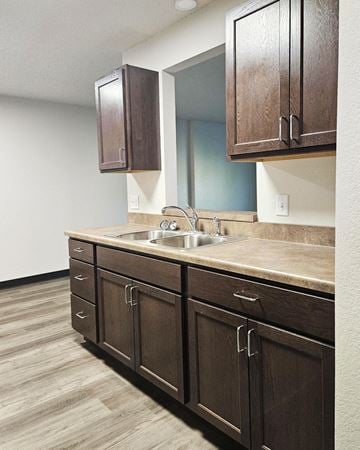 Alexandria apartment for rent - A kitchen with brown cabinets and a sink.