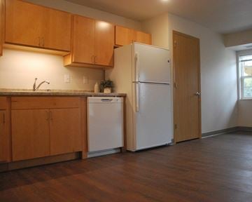 Le Sueur townhouse for rent - a kitchen with wooden cabinets and a white refrigerator