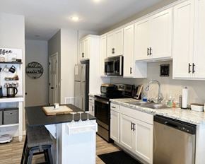 Mankato townhouse for rent - a kitchen with white cabinets and stainless steel appliances and a counter top