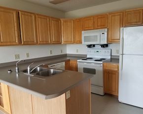 Marshall townhouse for rent - an empty kitchen with wooden cabinets and white appliances