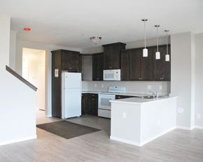 Northfield townhouse for rent - a kitchen with dark wood cabinets and white appliances