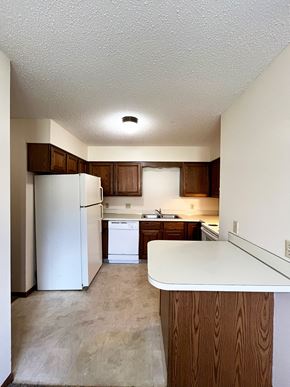 North Mankato apartment for rent - an empty kitchen with white appliances and wooden cabinets