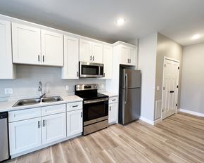 Mankato townhouse for rent - an empty kitchen with white cabinets and stainless steel appliances