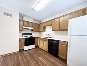 Mankato townhouse for rent - an empty kitchen with wood flooring and white appliances