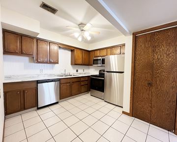 Mankato townhouse for rent - A kitchen with brown cabinets and white appliances.